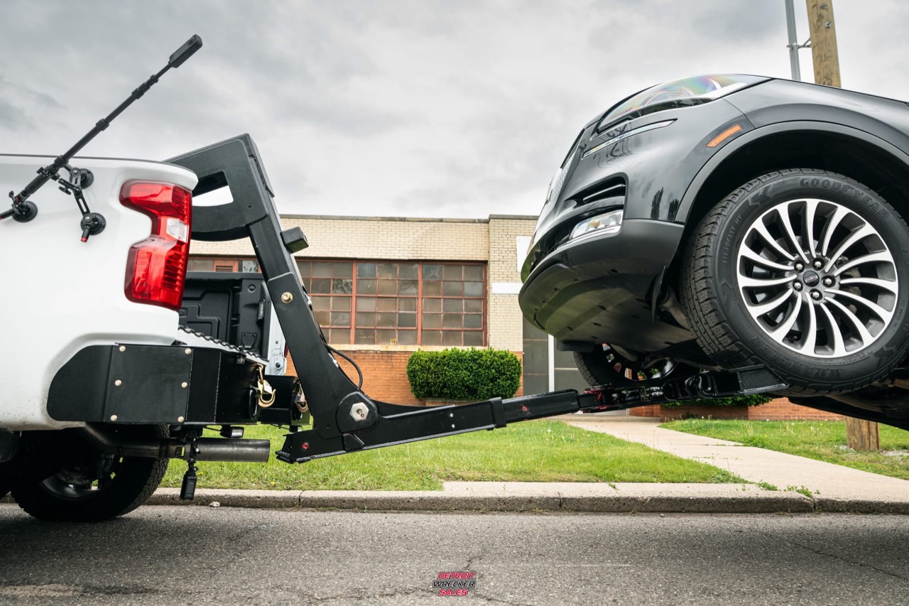 Baby Gladiator lifting the front wheels of a gray SUV.