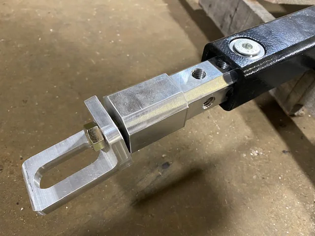 Adjustable metal L-arm extender fitted to a Detroit wheel-lift arm.