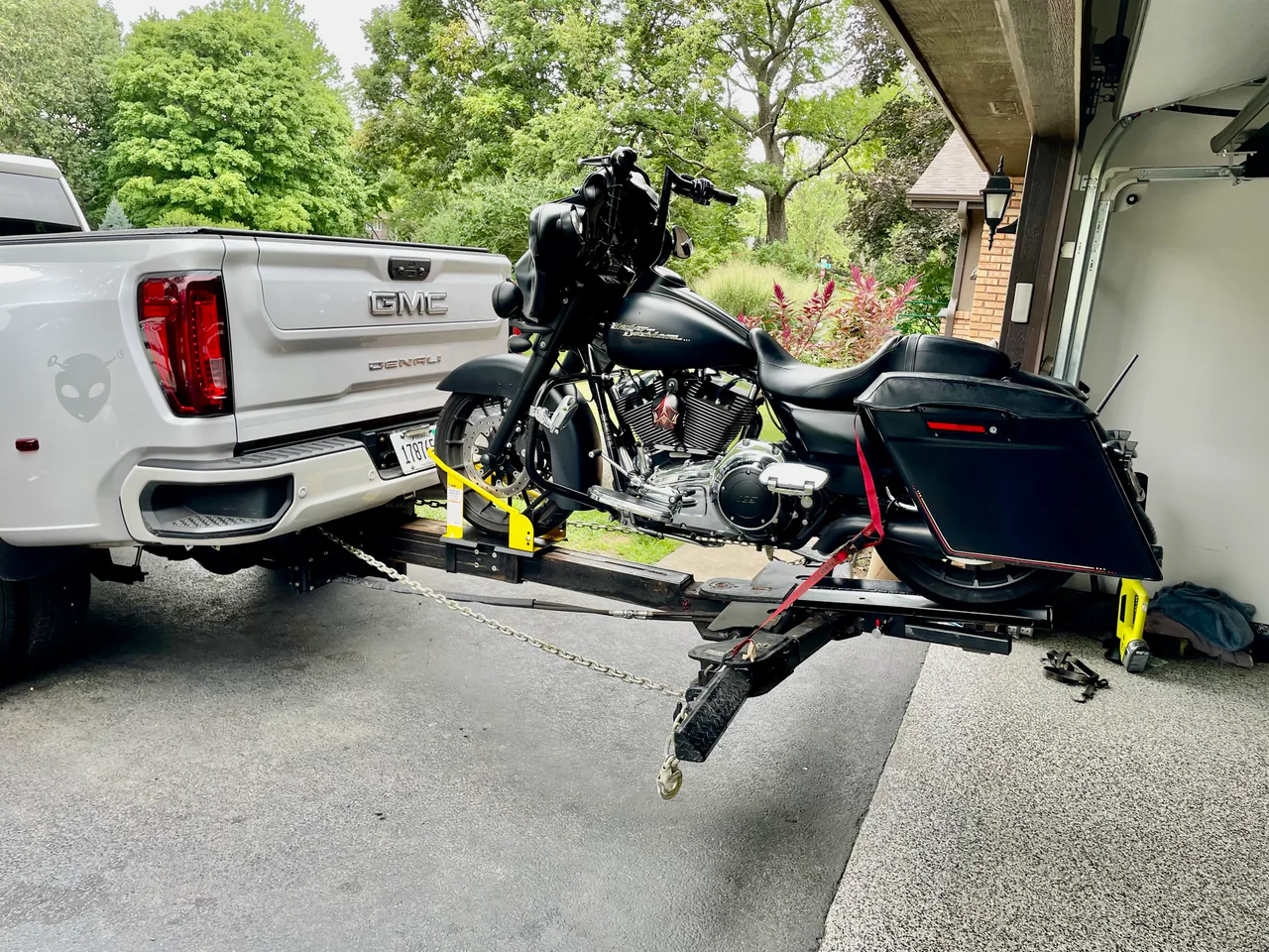 Black touring motorcycle on a Lil Hercules motorcycle attachment behind a white GMC pickup.
